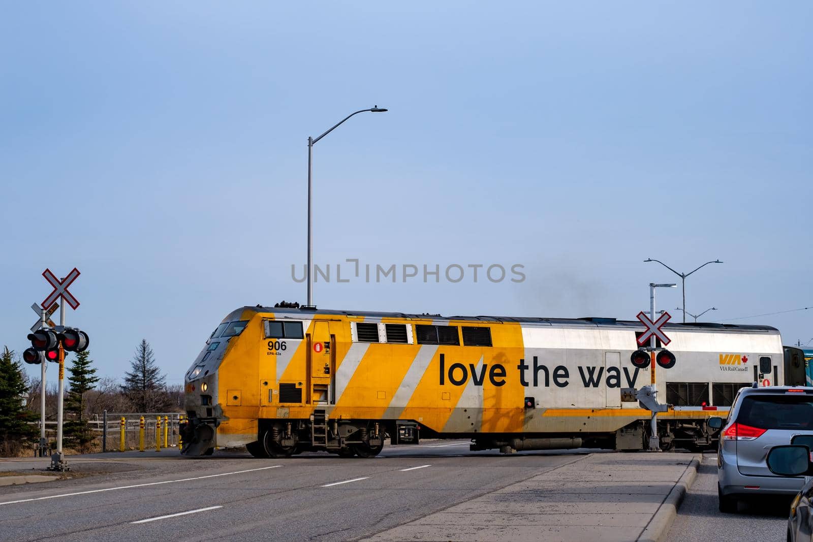 Ottawa, Ontario, Canada - March 25, 2021: A Via Rail train crosses Woodroofe Avenue as it departs Fallowfield Station north of Barrhaven.