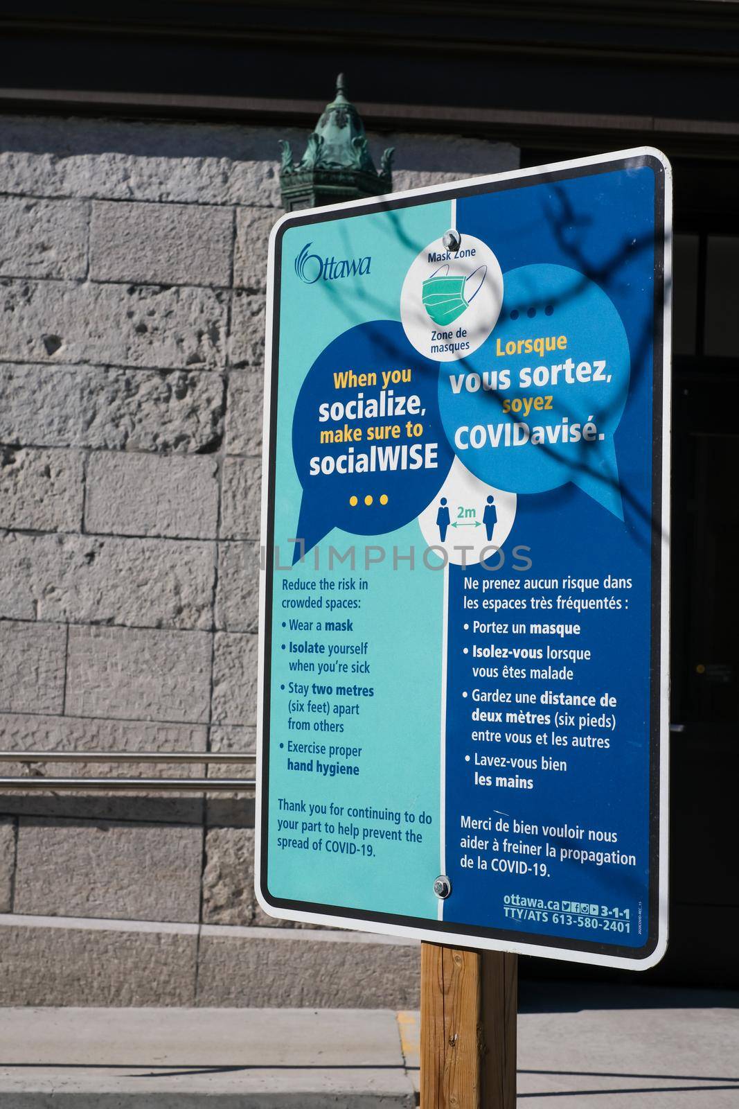 Ottawa, Ontario, Canada - March 15, 2021: A sign posted by the City of Ottawa in the ByWard Market promotes public health precautions during the COVID-19 pandemic.
