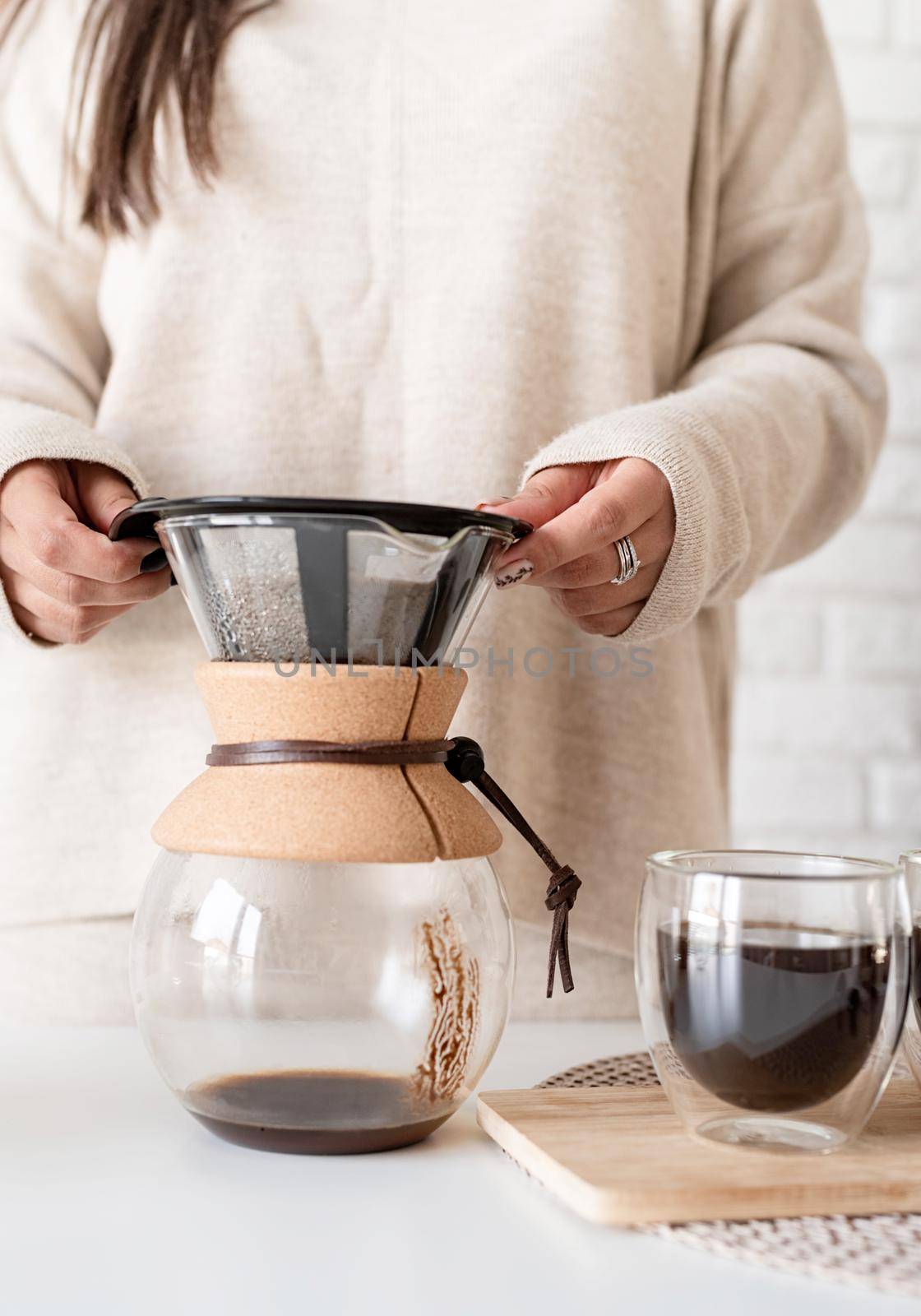 Alternative coffee brewing. Young woman brewing coffee in coffee pot and cutting a cake