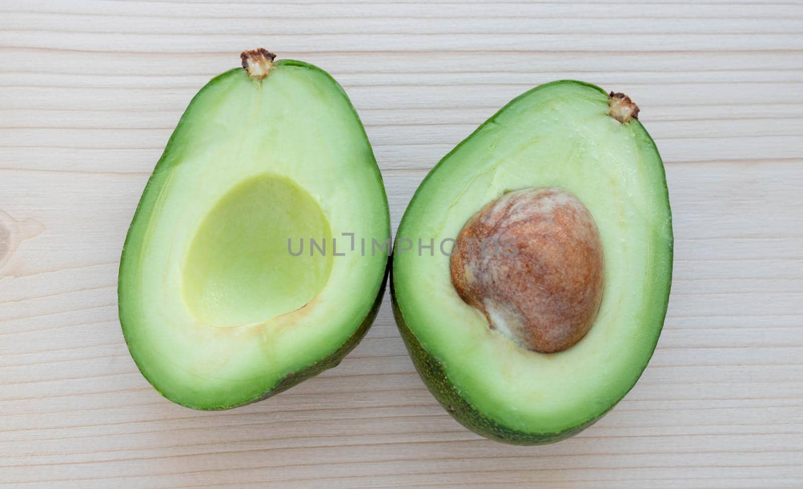 Slices of ripe avocado lie on a light cutting board.