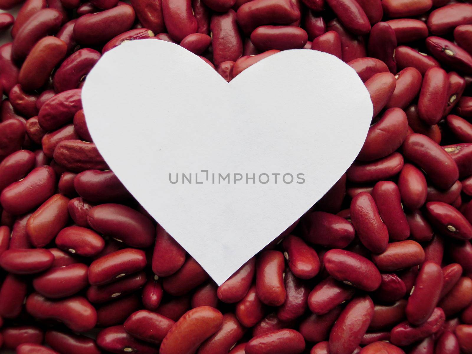 Closeup of White Heart shape on Raw Red Kidney Beans Background by aroas