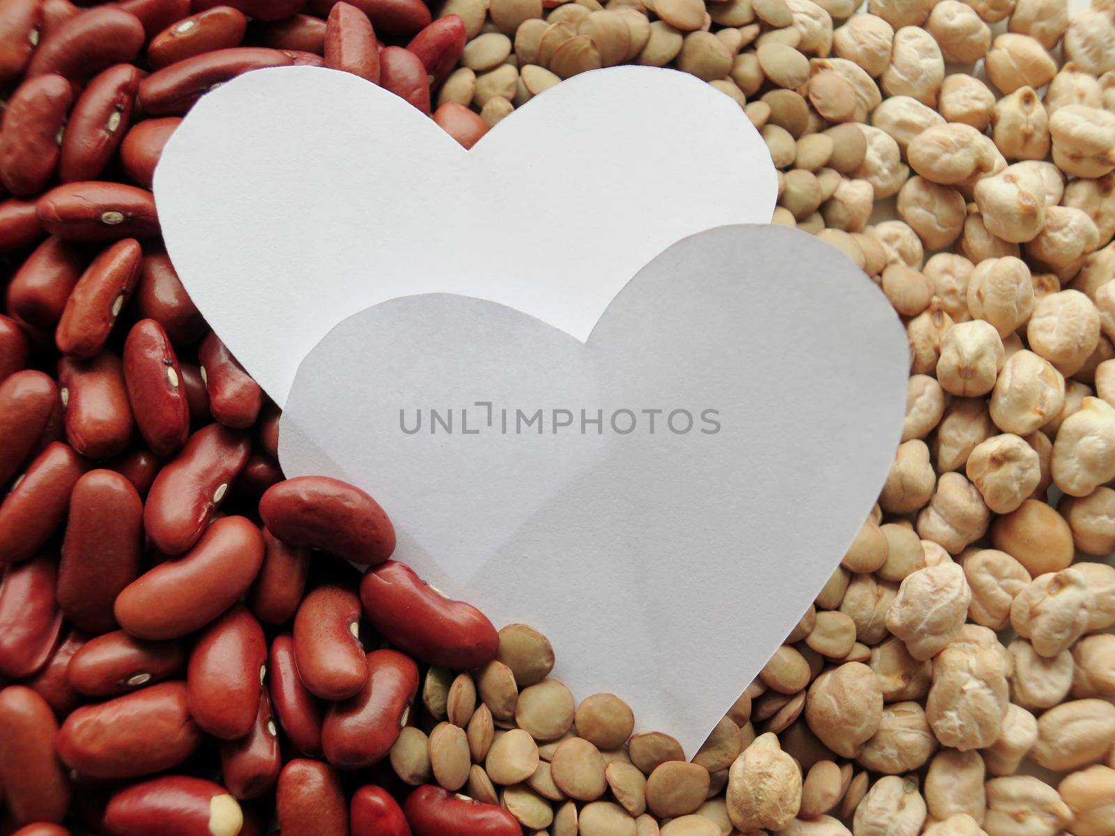 White Heart shape on Raw Red Beans, lentils and chickpeas Background. healthy food