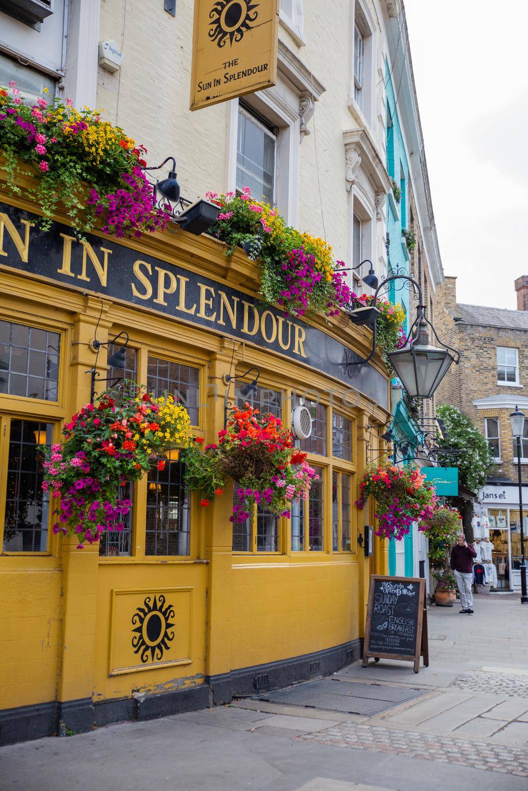 London, UK - February 14, 2020: Front side of The Sun in Splendour pub and restaurant covered with flowers. Flowered yellow restaurant building. Great London restaurants