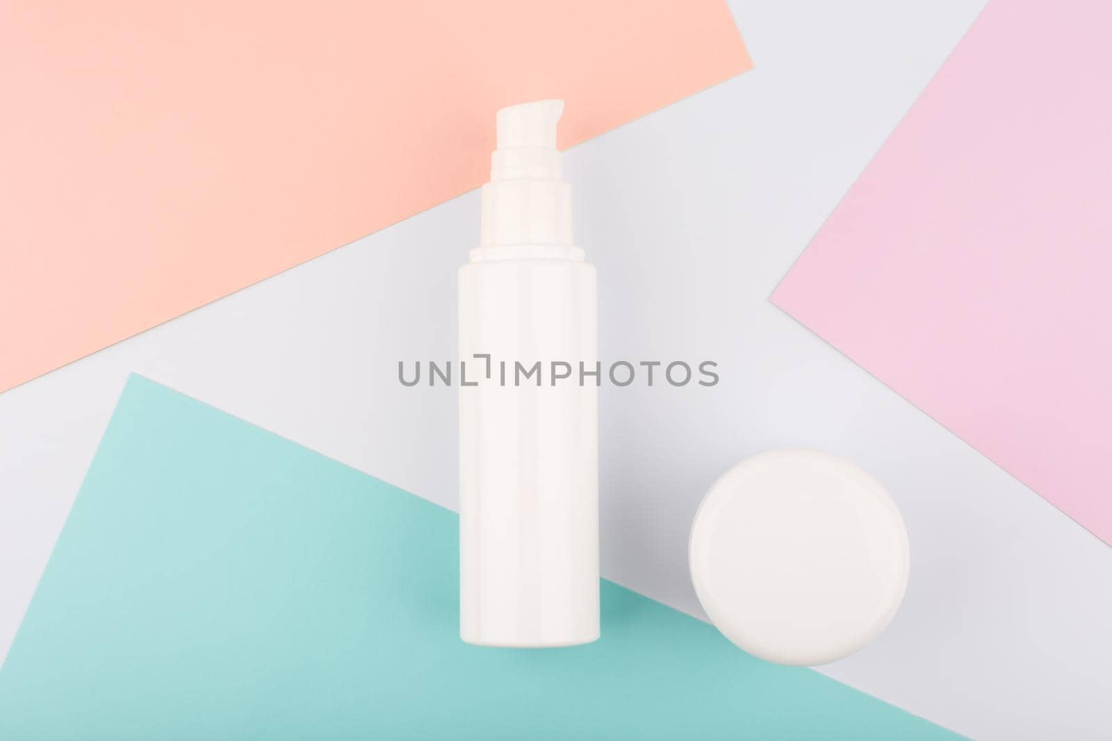 Face cream or lotion and under eye gel or lip balm on white background with colorful pieces of paper. High quality photo