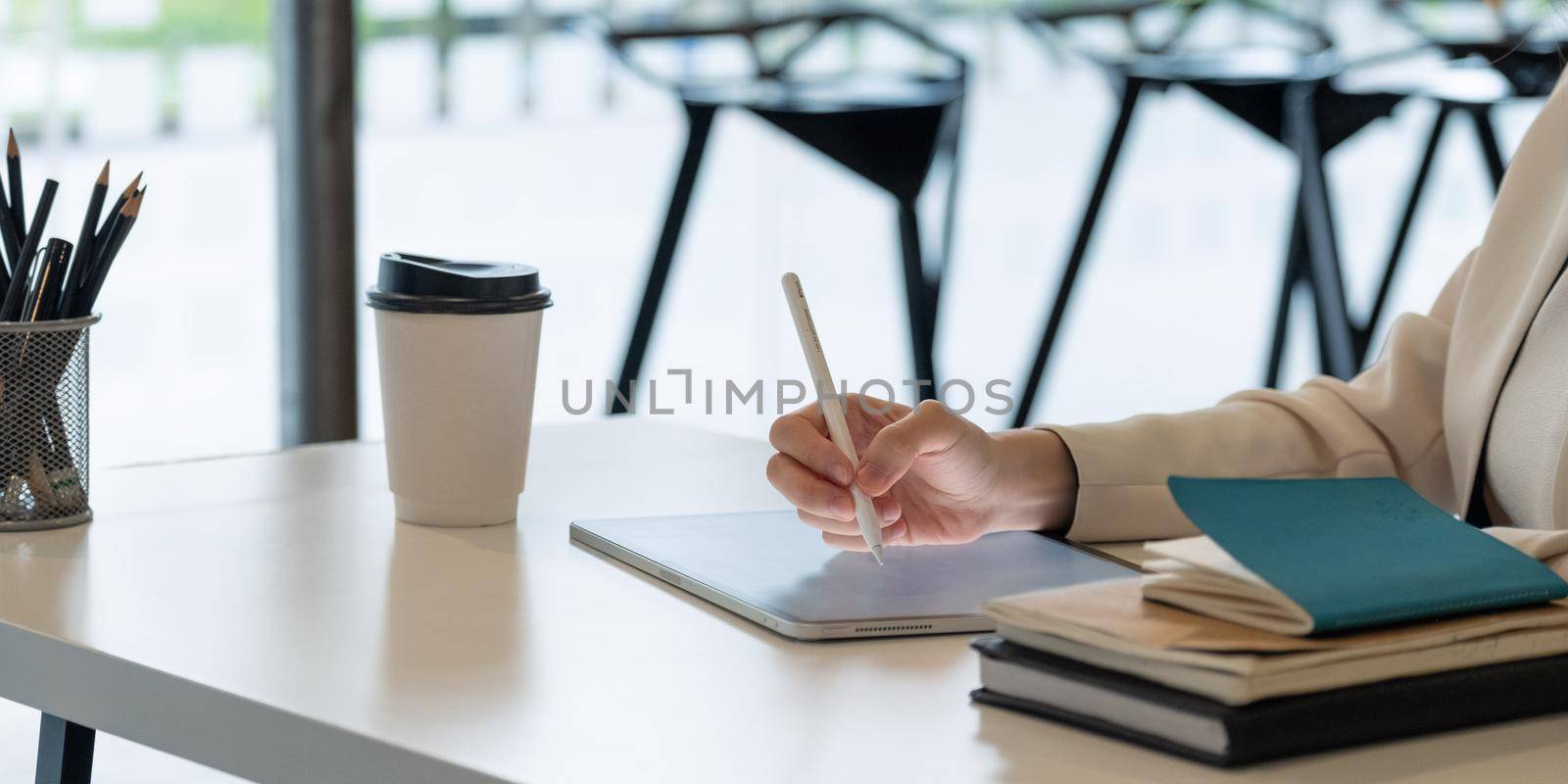Close uo businesswoman holds pen stylus drawing on digital tablet on workplace.