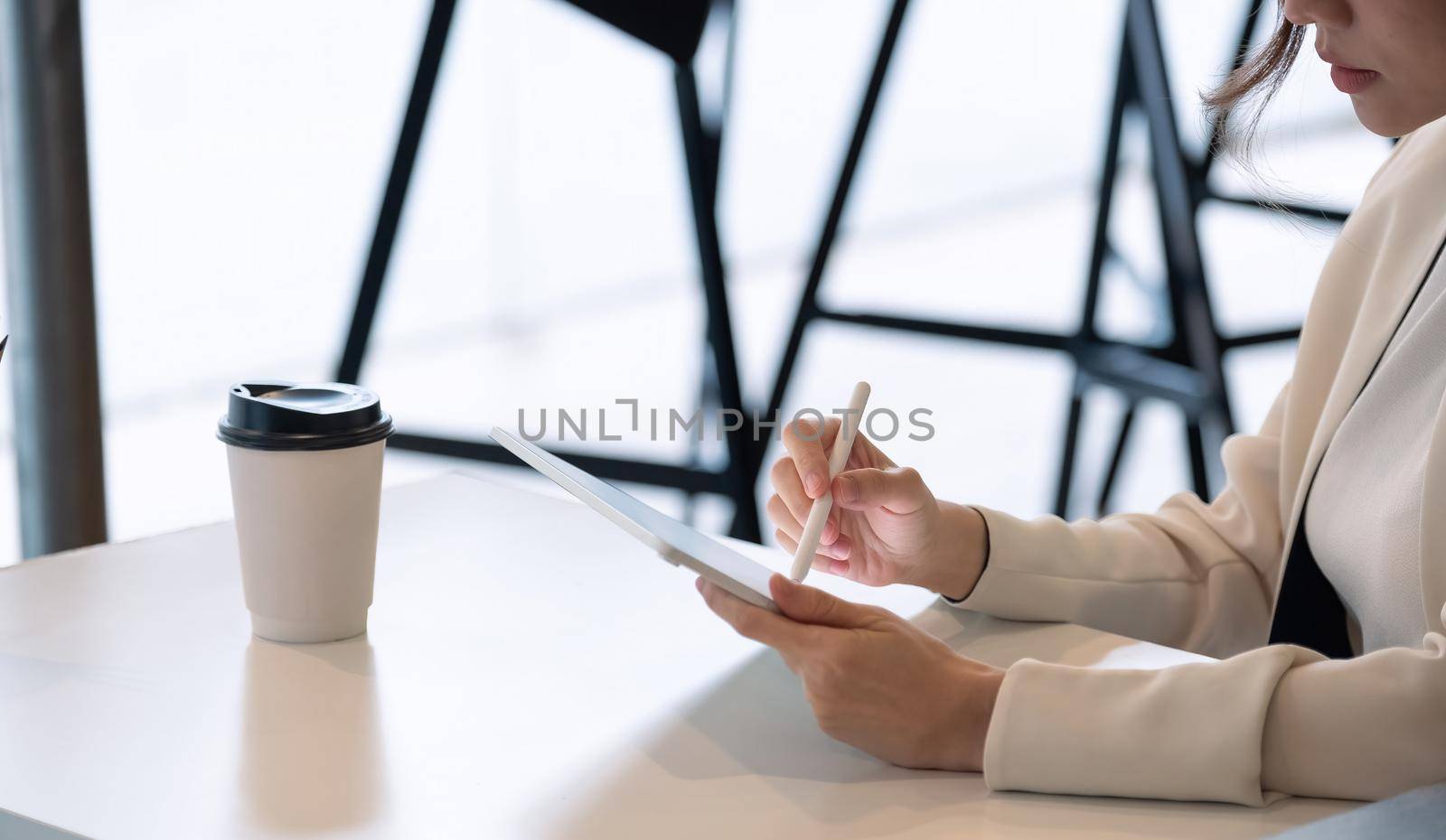 Close up businesswoman holds pen stylus drawing on digital tablet on workplace