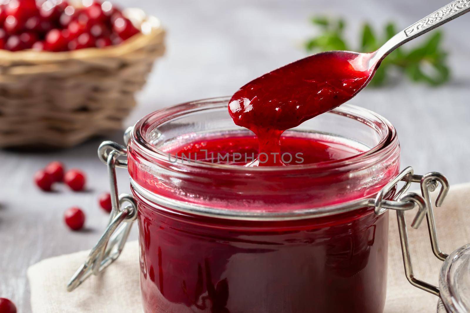 Glass jar with homemade lingonberry sauce. Canning lingonberry sauce.