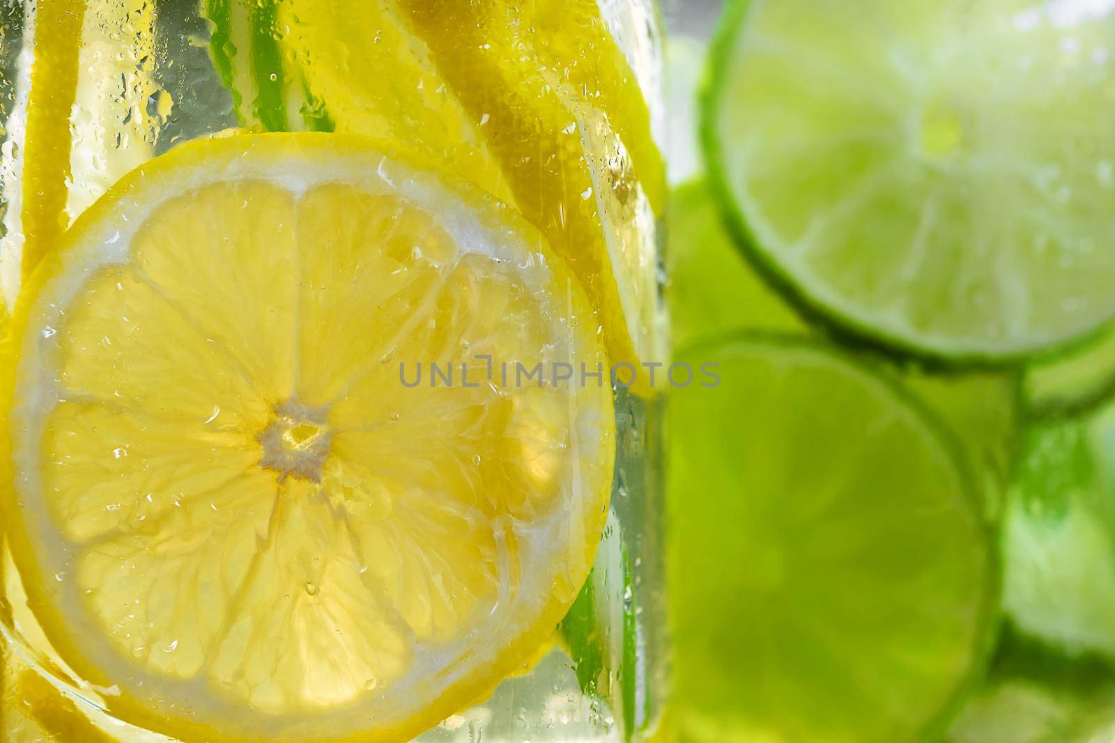 Cold refreshing homemade lemonade with mint, lemon and lime in mason jars by galsand