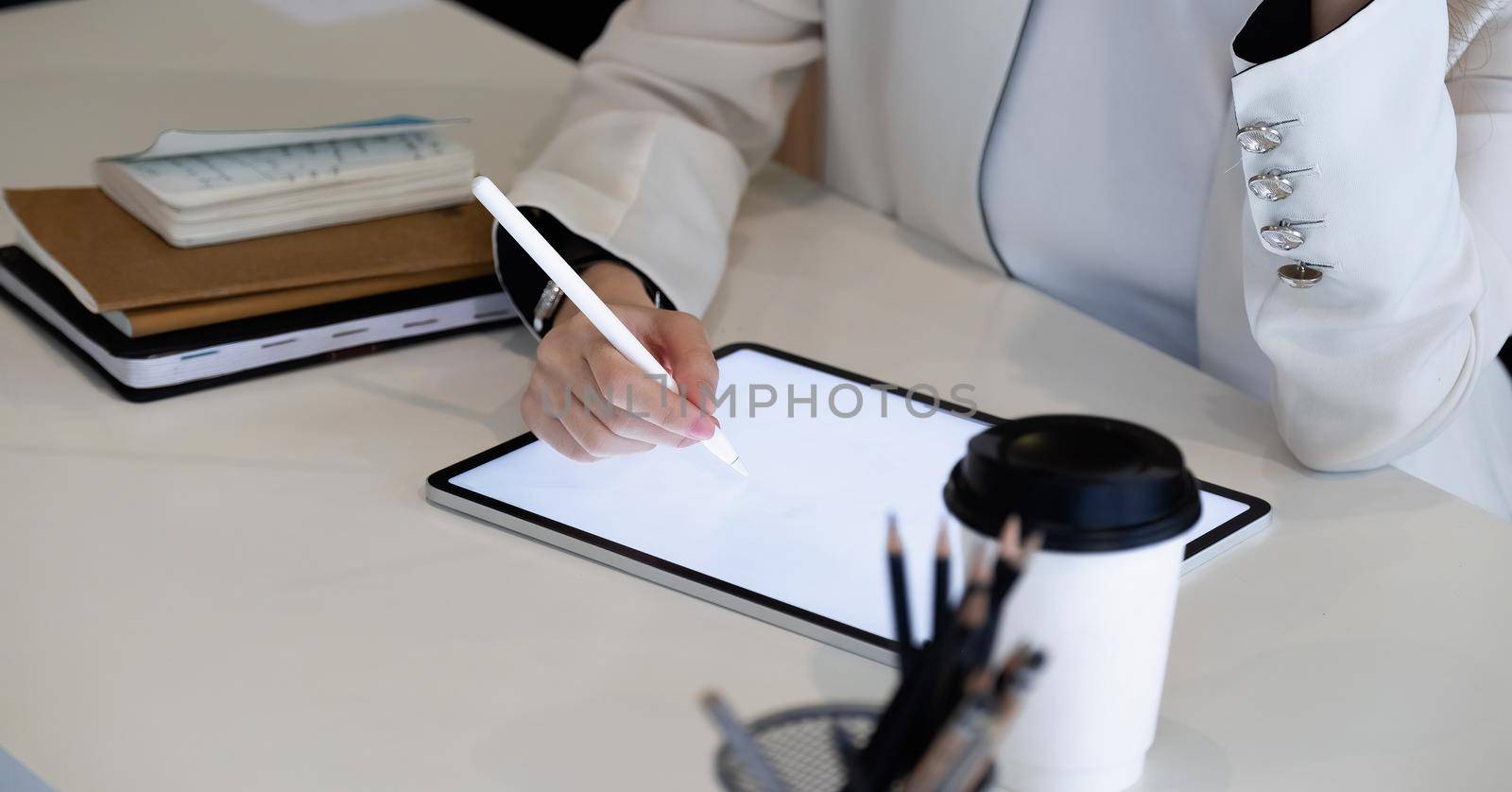Close uo businesswoman holds pen stylus drawing on digital tablet on workplace.
