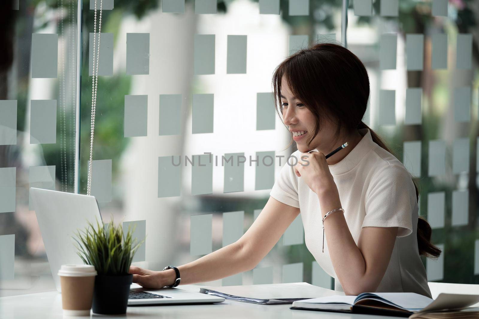 Happy asian woman using laptop computer for video conference. Online business education concept by nateemee