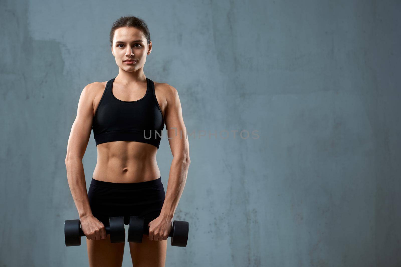 Muscular fitnesswoman carrying dumbbells. by SerhiiBobyk