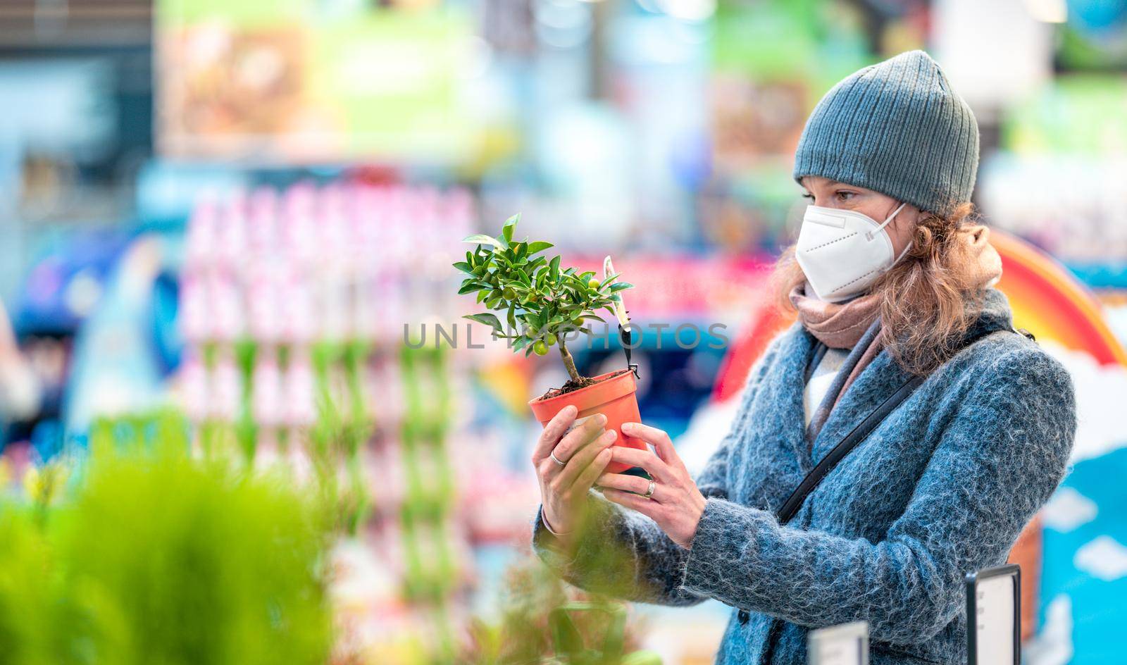 buying plants in a flowerpot in the garden center by Edophoto