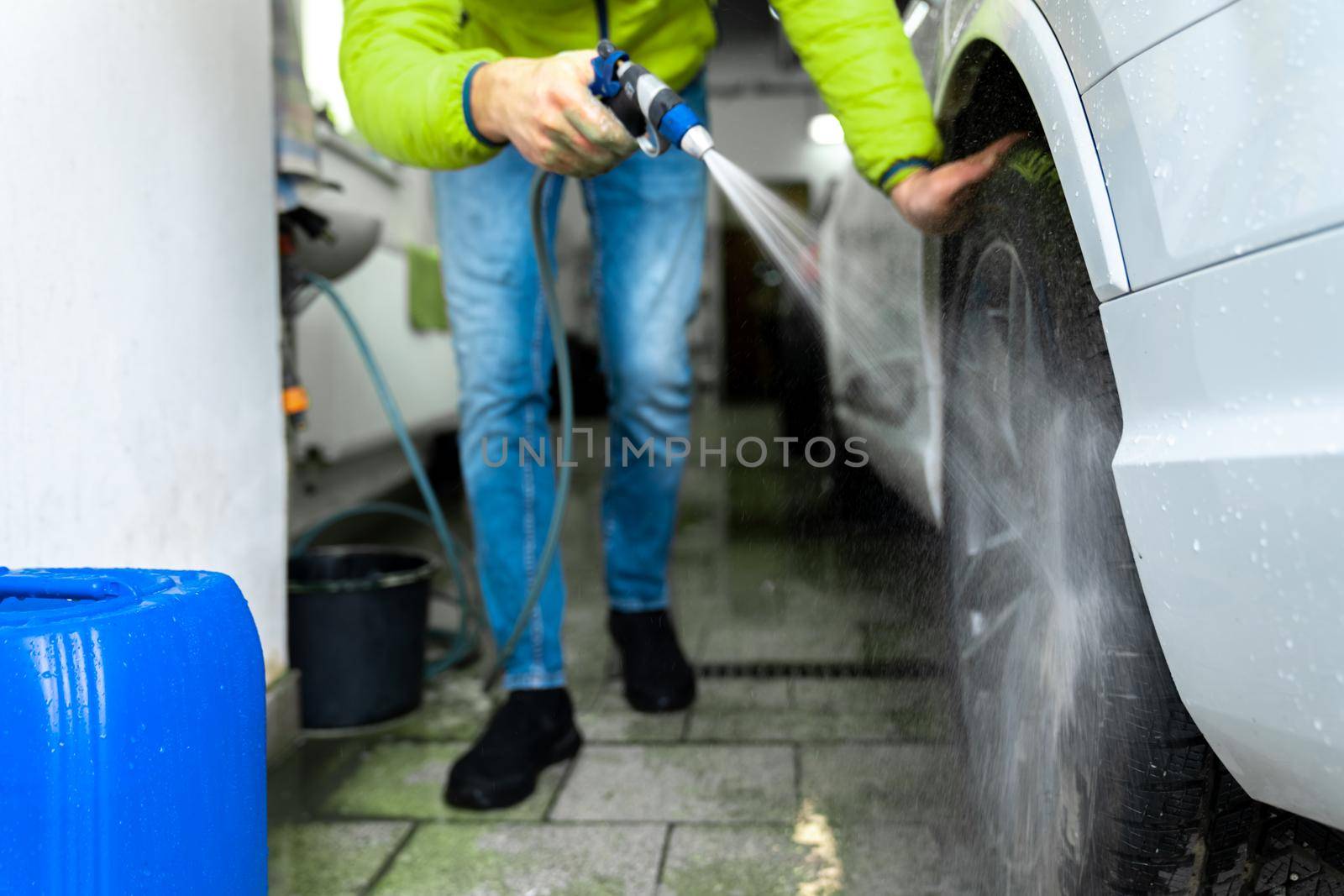 manually wash car wheels using pressure hoses with water.