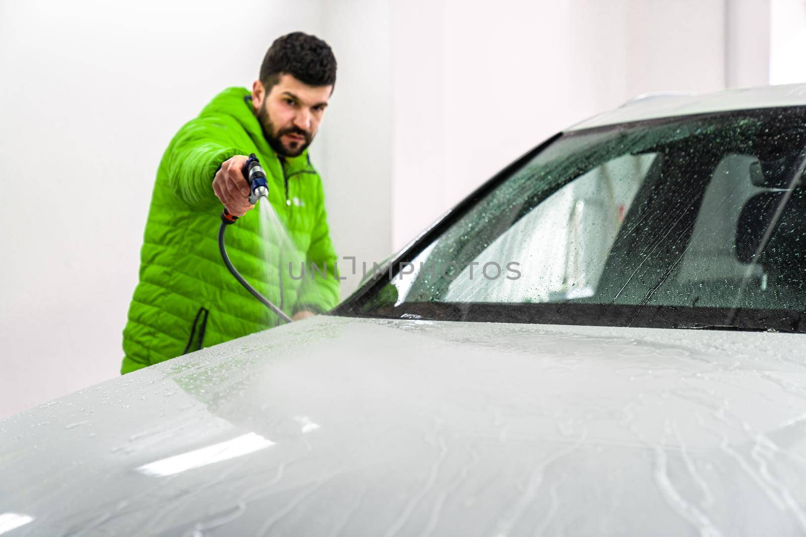 wash the car by spraying water from a high pressure hose with foam by Edophoto