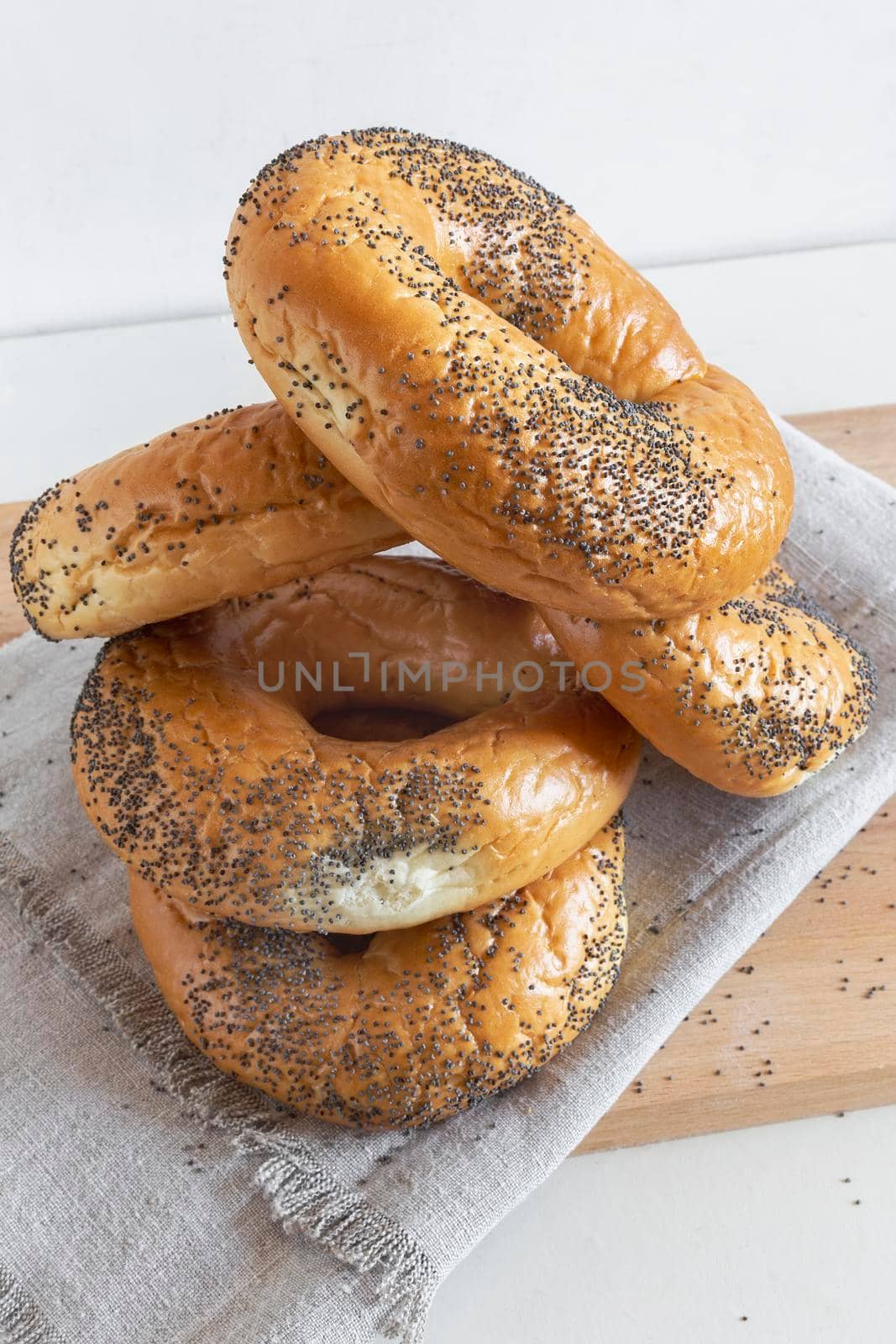 Some delicious bagels with poppy seeds on a napkin close-up. Front view.