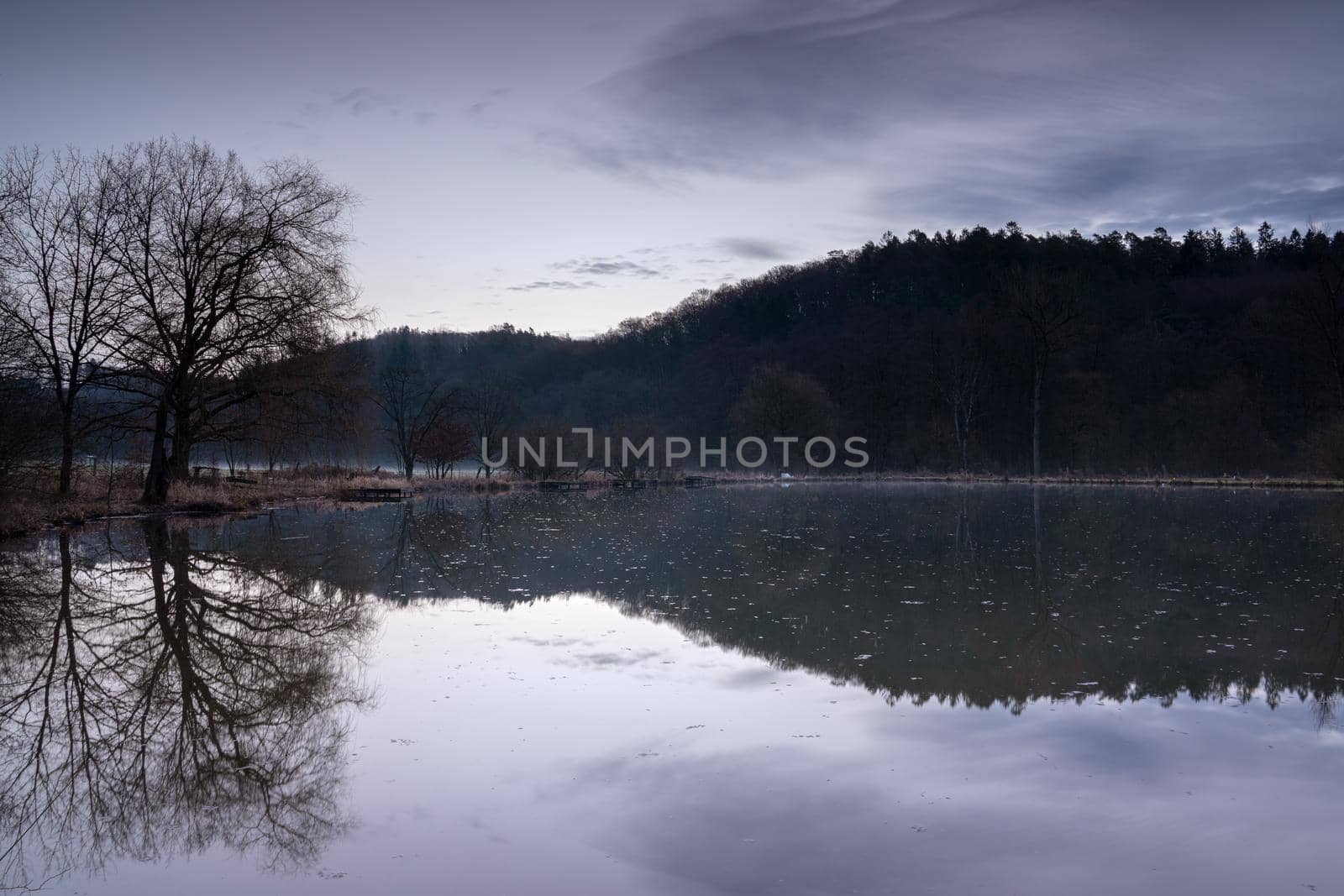 Fishpond close to Lindlar with water reflection during early morning mood, Bergisches Land, Germany