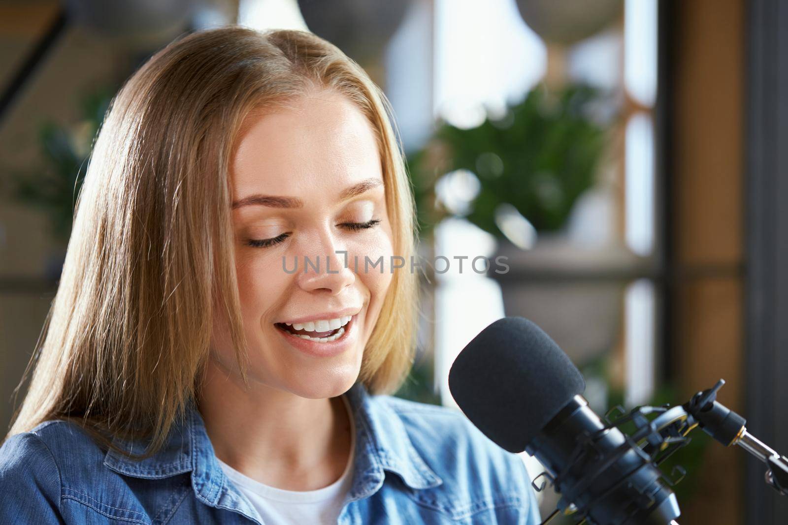 Young woman working on radio with modern microphone.  by SerhiiBobyk