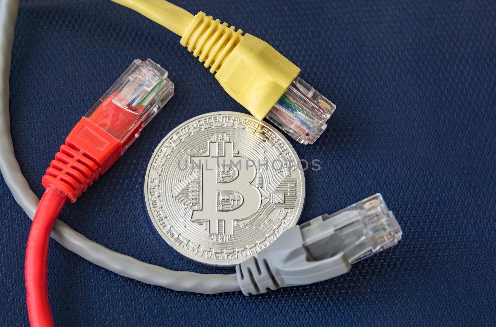 Metal coin of bitcoin with color ethernet plugs around