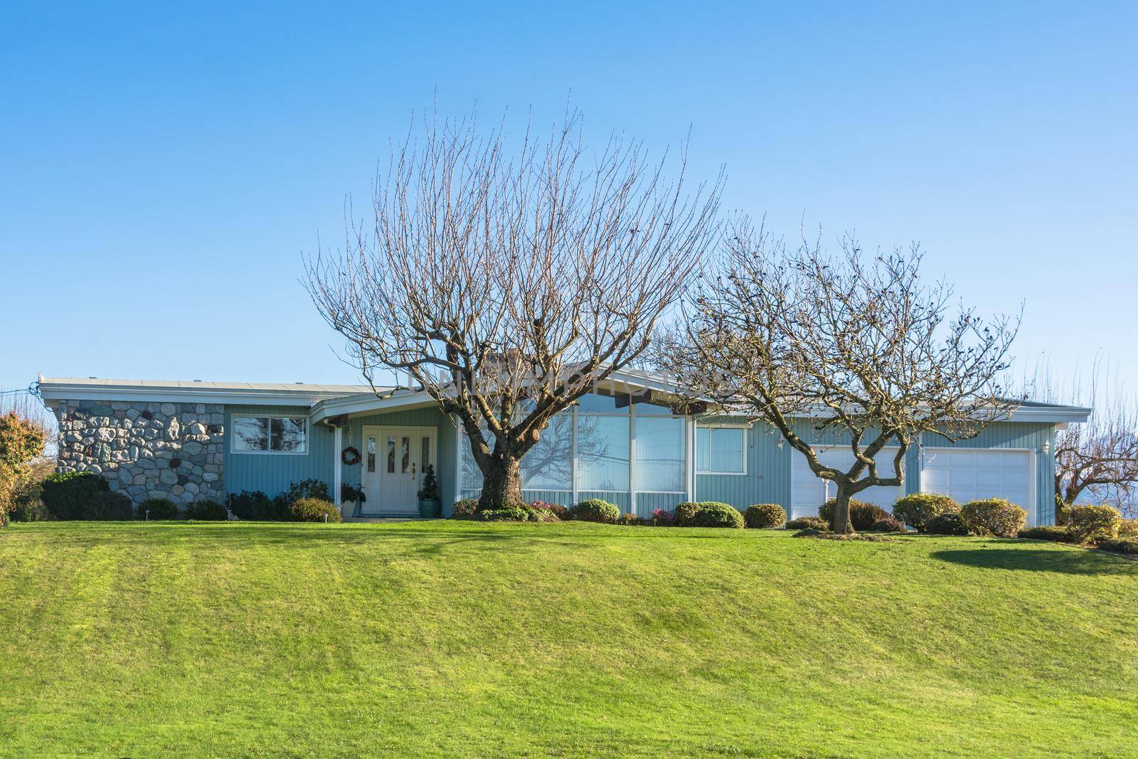 Ranch style residential house with big front yard and two garages