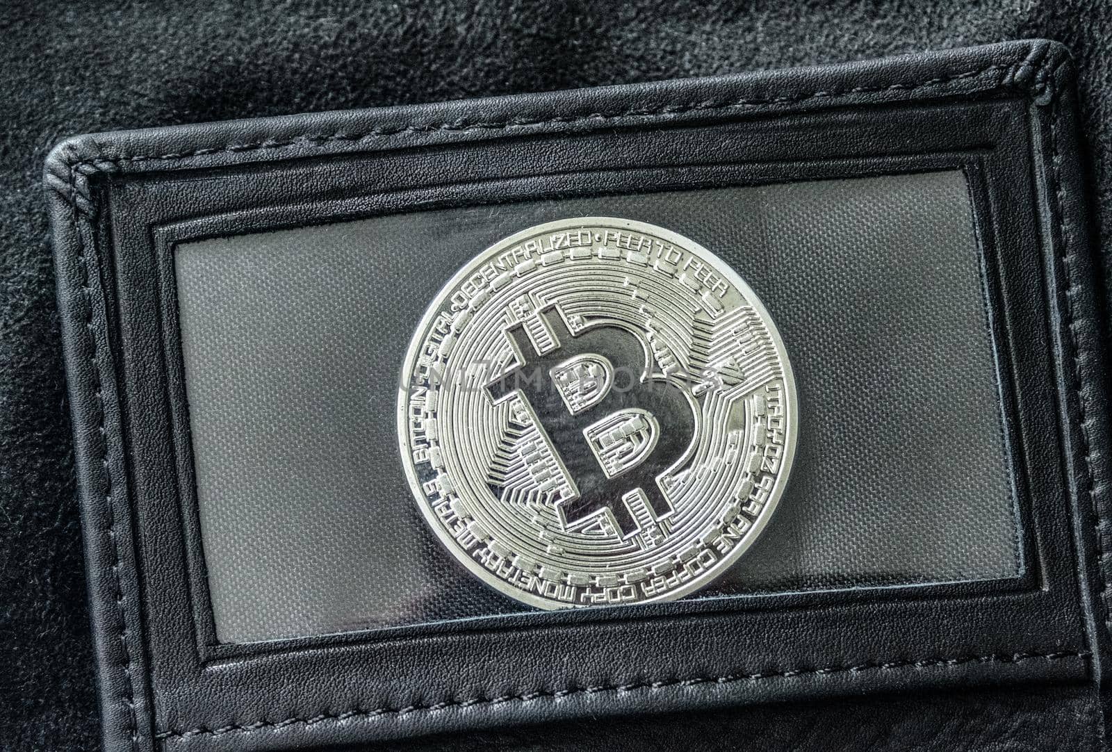 Bitcoin in leather wallet under transparent film