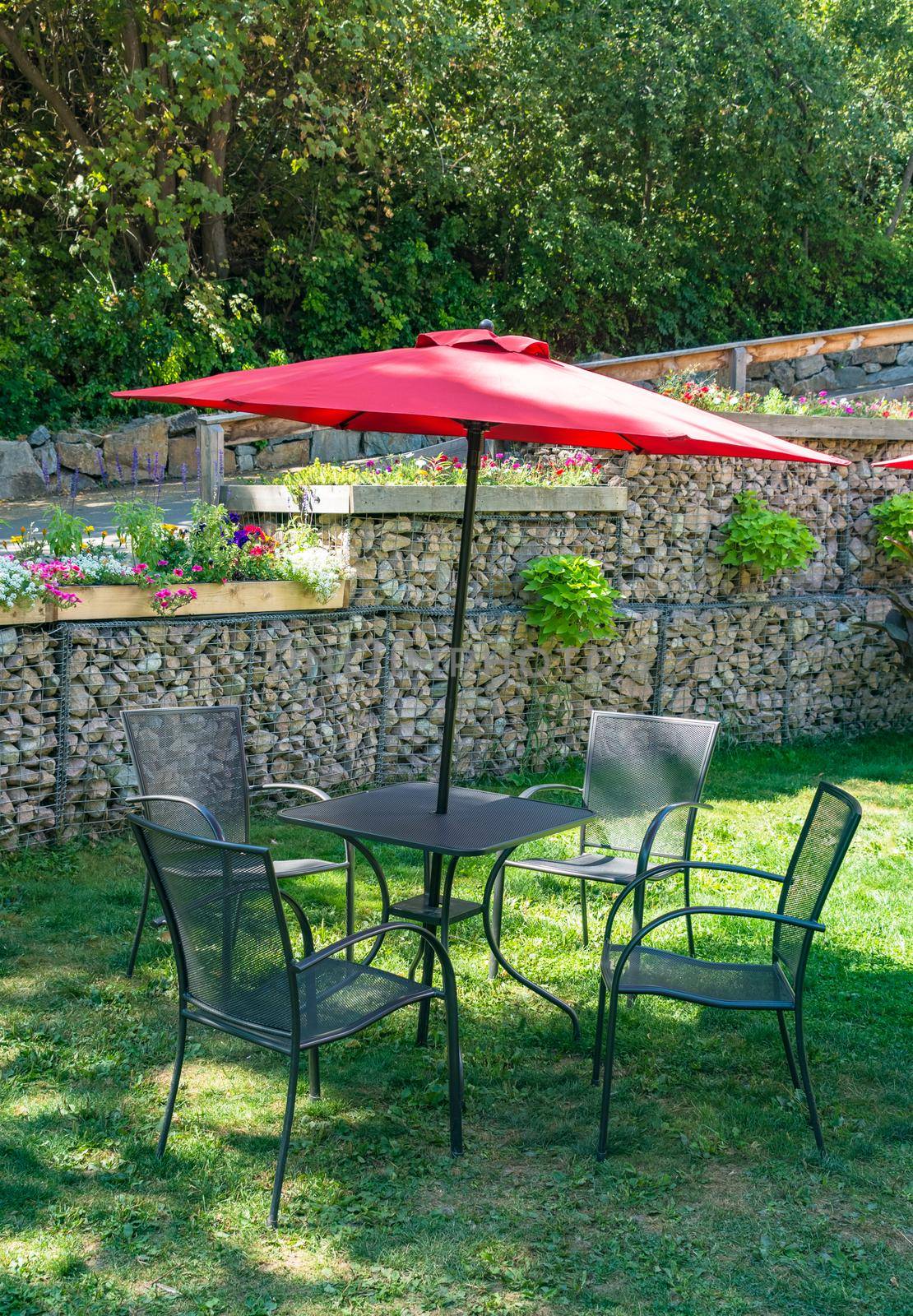 Outside cafe table on green lawn under the red umbrella canopy