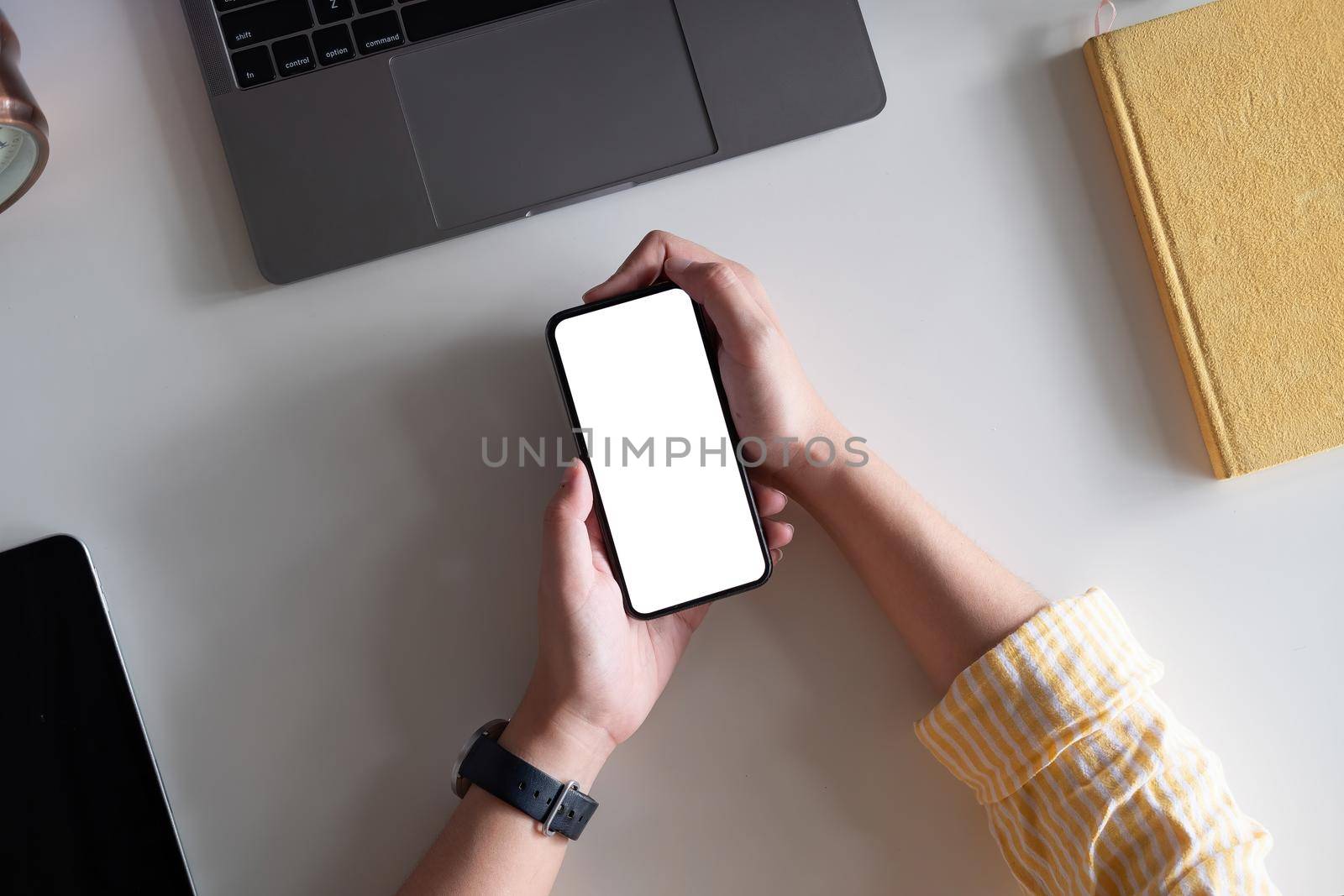 Top view Woman sitting and holding blank screen mock up mobile phone