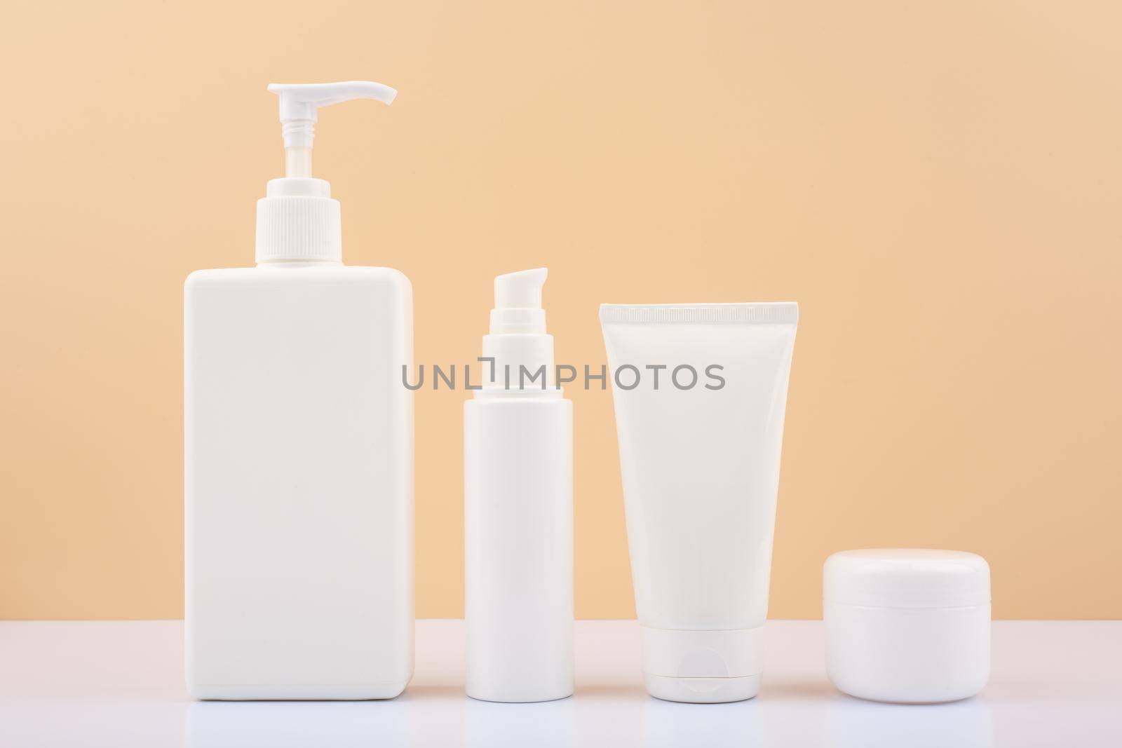 Set of cosmetic products for skin care on white table against bright beige background. Concept of beauty treatment by Senorina_Irina