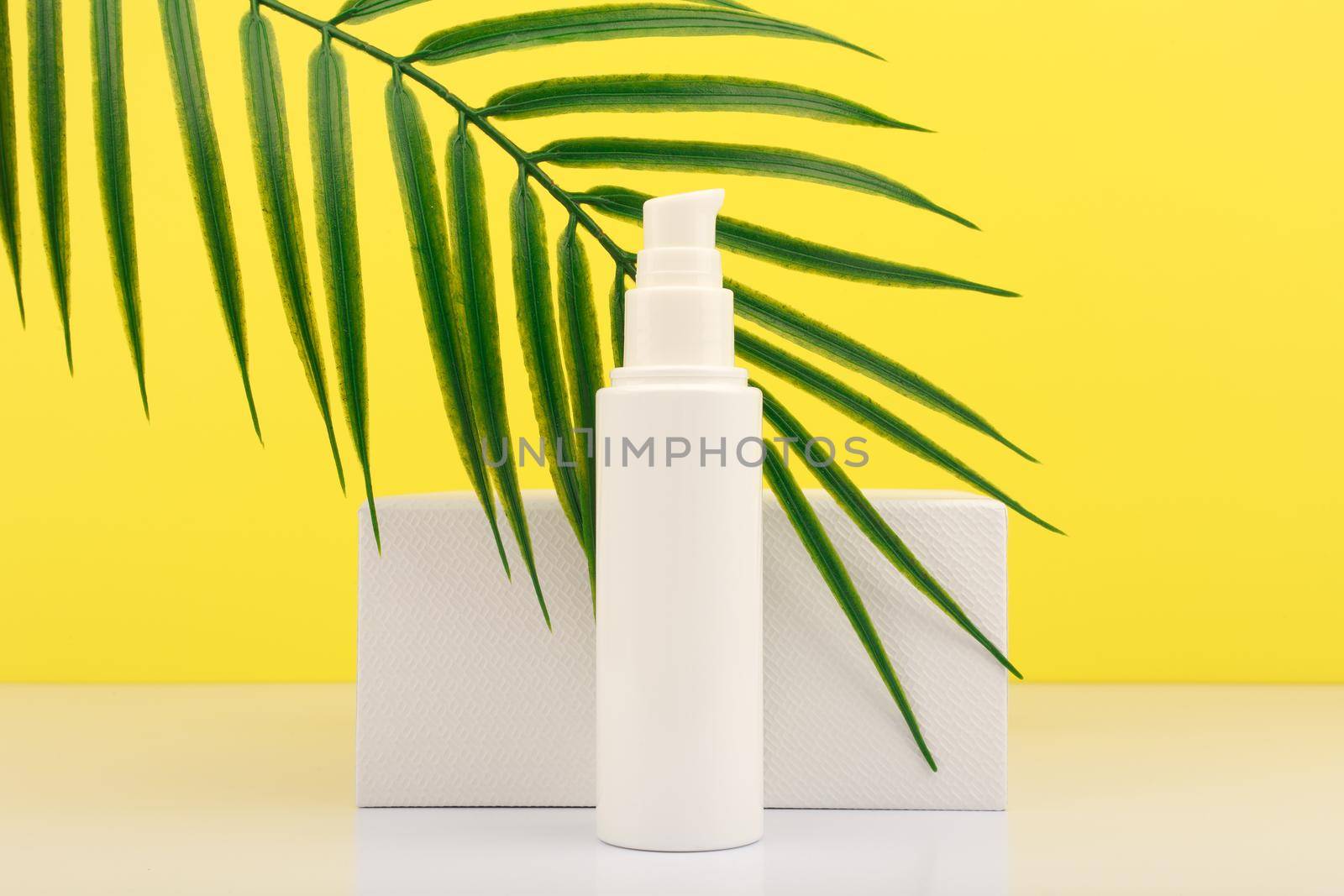 Summer face cream with SPF with white geometric podium and palm leaf against yellow background. Concept of sunblock by Senorina_Irina
