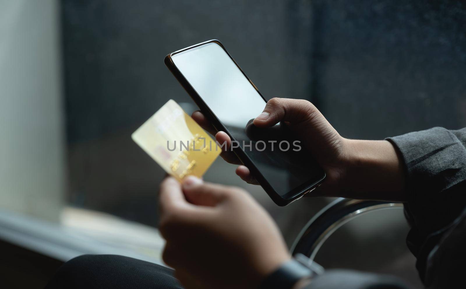 Close up woman at home shopping online with credit card and smart phone by nateemee