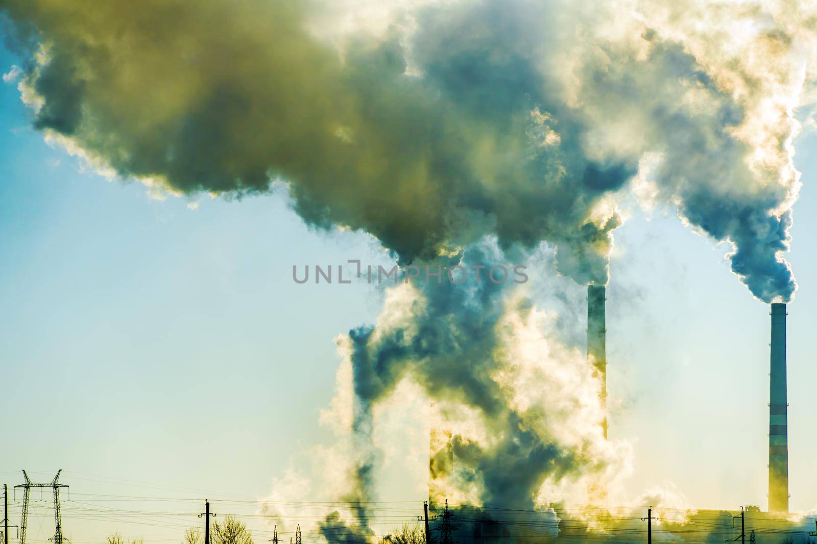 Smoking factory chimneys.Environmental problem of pollution of environment and air in large cities.Climate change,ecology and global warming.The sky is smoky with toxic substances.Soot from factories