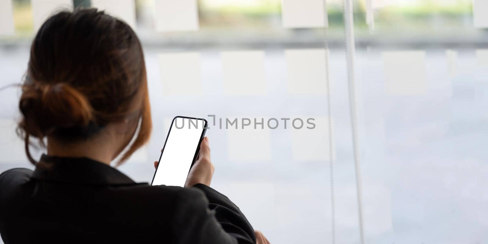 Close up business woman using smart phone with white blank screen at office.