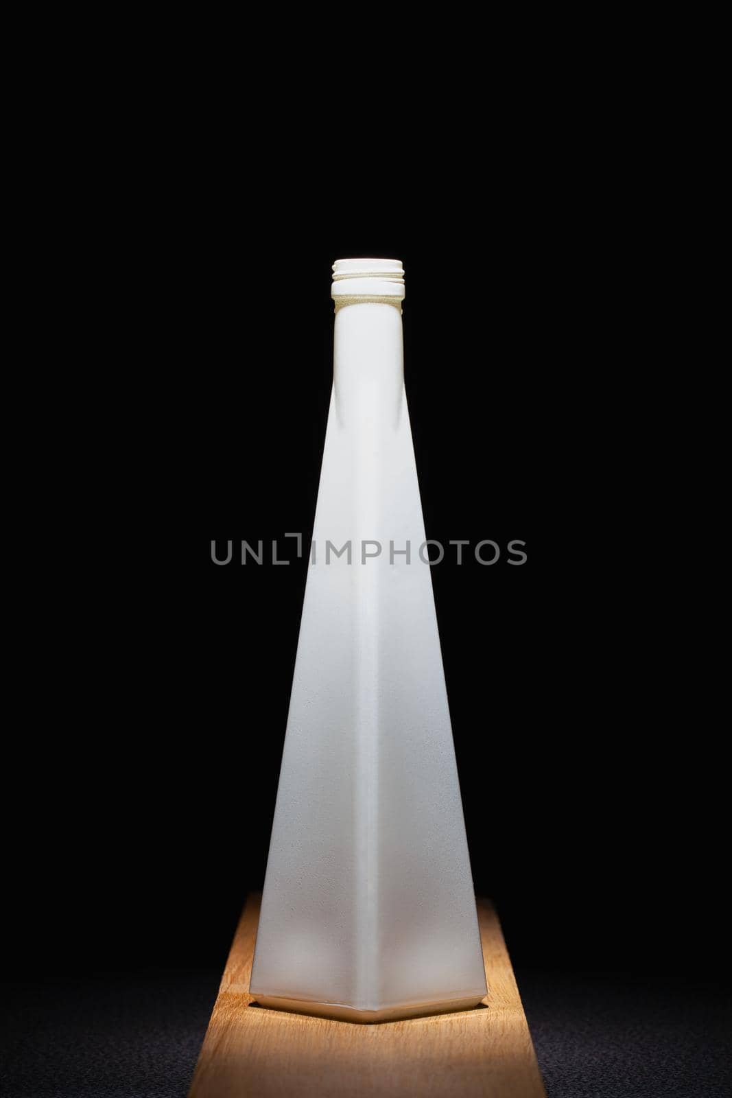 White empty vase on the wooden table in the dark room.  by CaptureLight