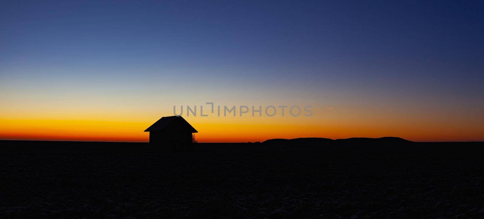 Old barn on the field in the blue hour.