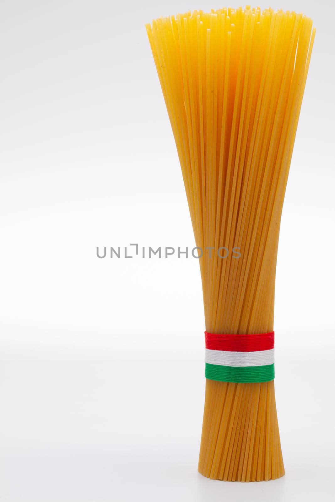 Bundle of spaghetti and Italian flag on the white background.