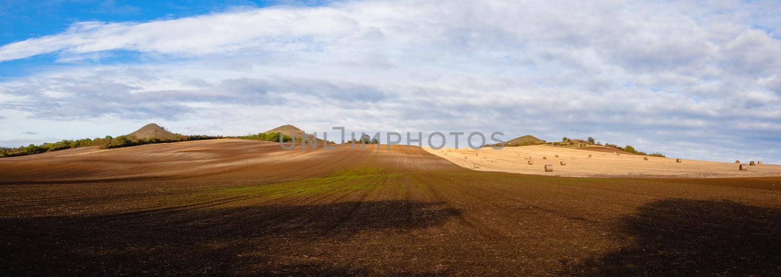 Straw bales on a stubble in Central Bohemian Uplands, Czech Republic. Field landscape bales of straw on a farm field. Panorama Image.