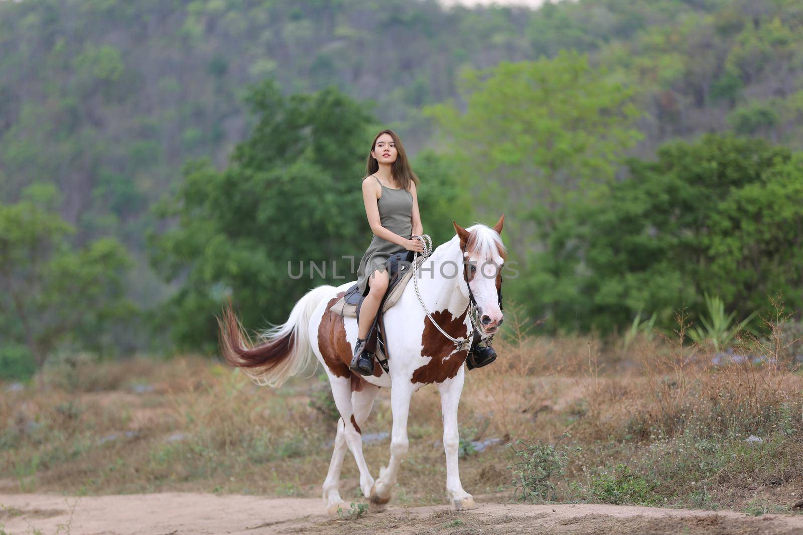 Women on skirt dress Riding Horses On field landscape Against Sky During Sunset