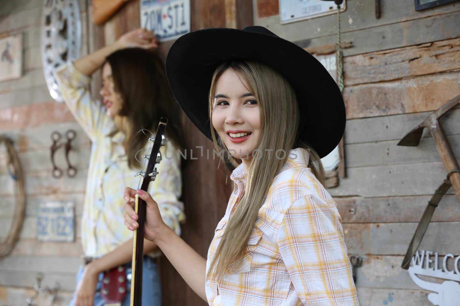 A woman in a cowgirl style sits in a horse ranch with a western farm environment. by chuanchai