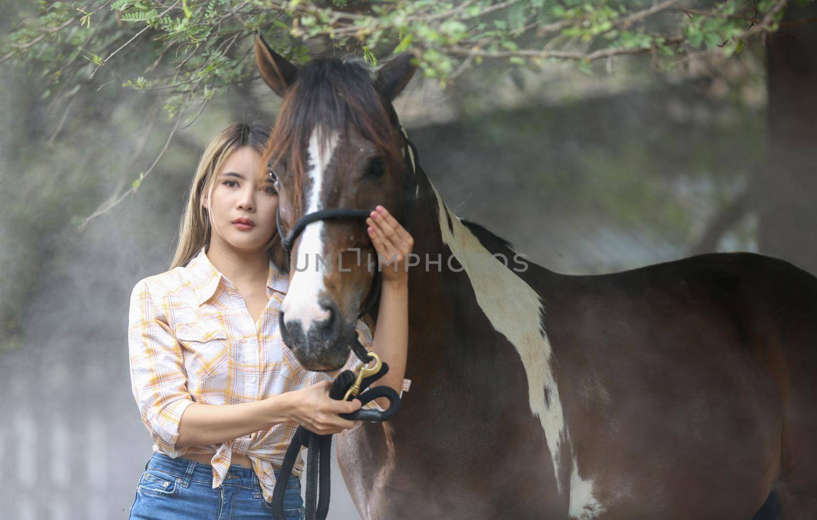 A woman in a cowgirl style sits in a horse ranch with a western farm environment.
