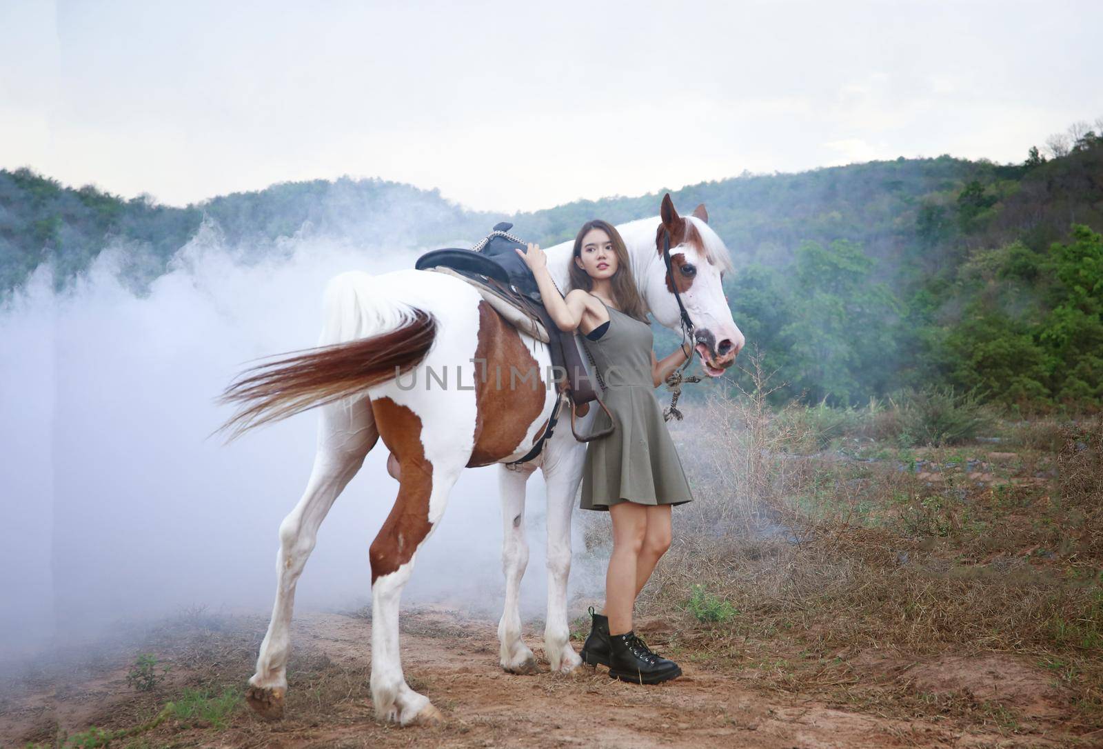 Woman with horse standing on field