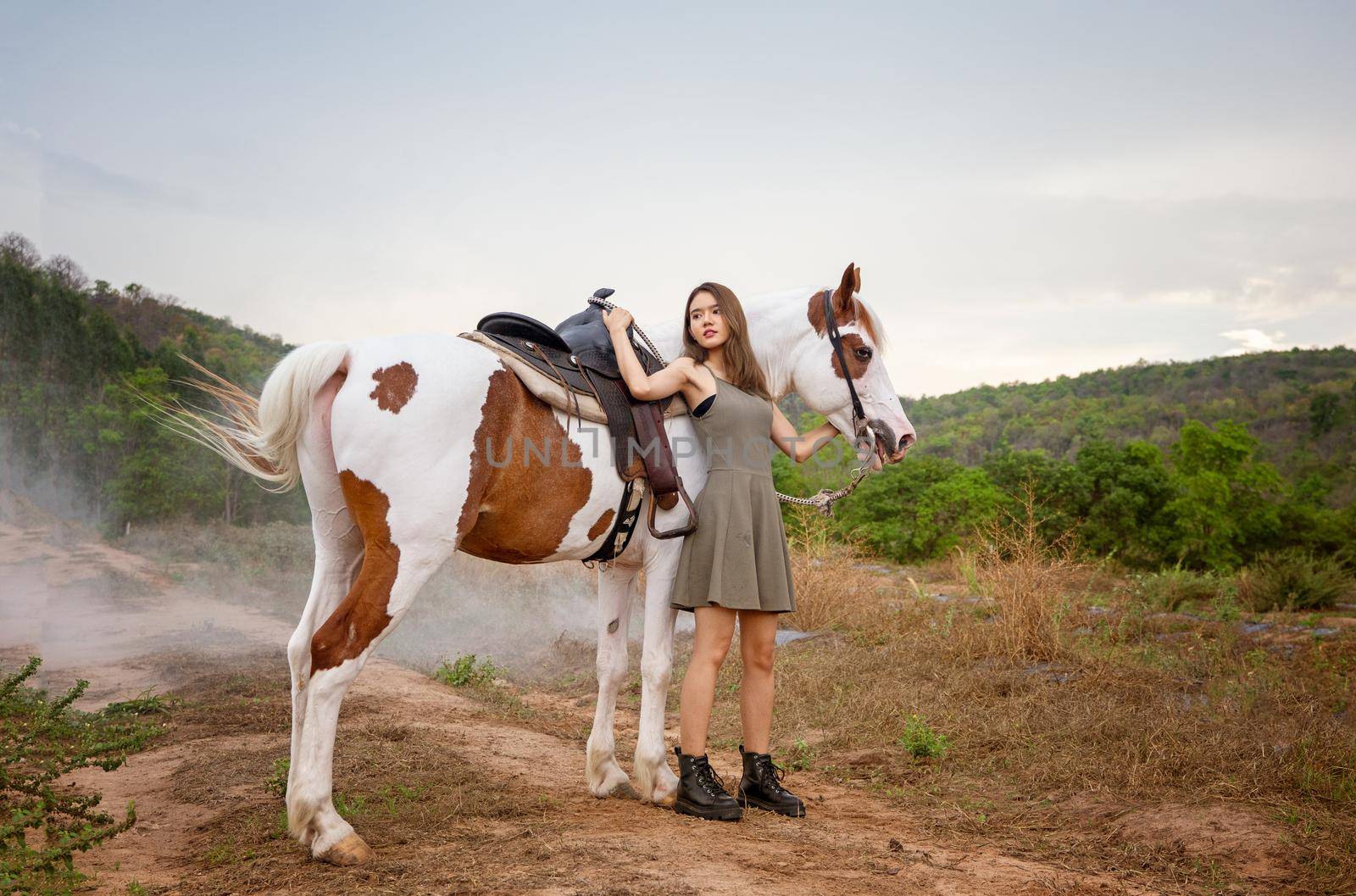 Woman with horse standing on field