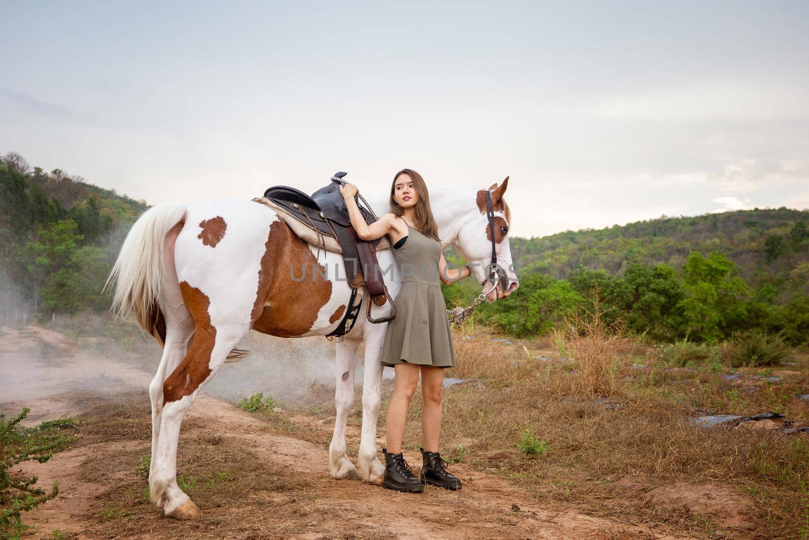 Woman with horse standing on field