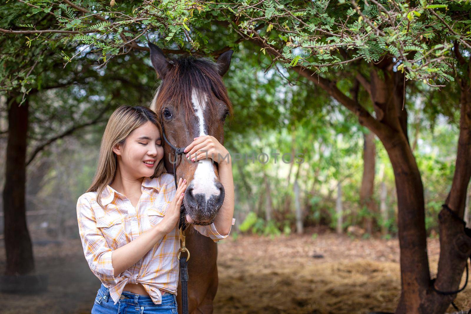 A woman in a cowgirl style sits in a horse ranch with a western farm environment.