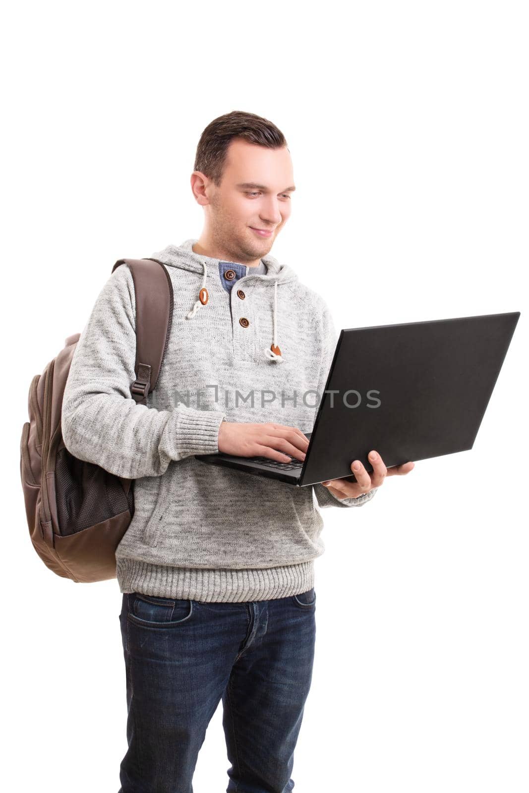 Young guy in casual clothing and backpack holding open laptop by Mendelex