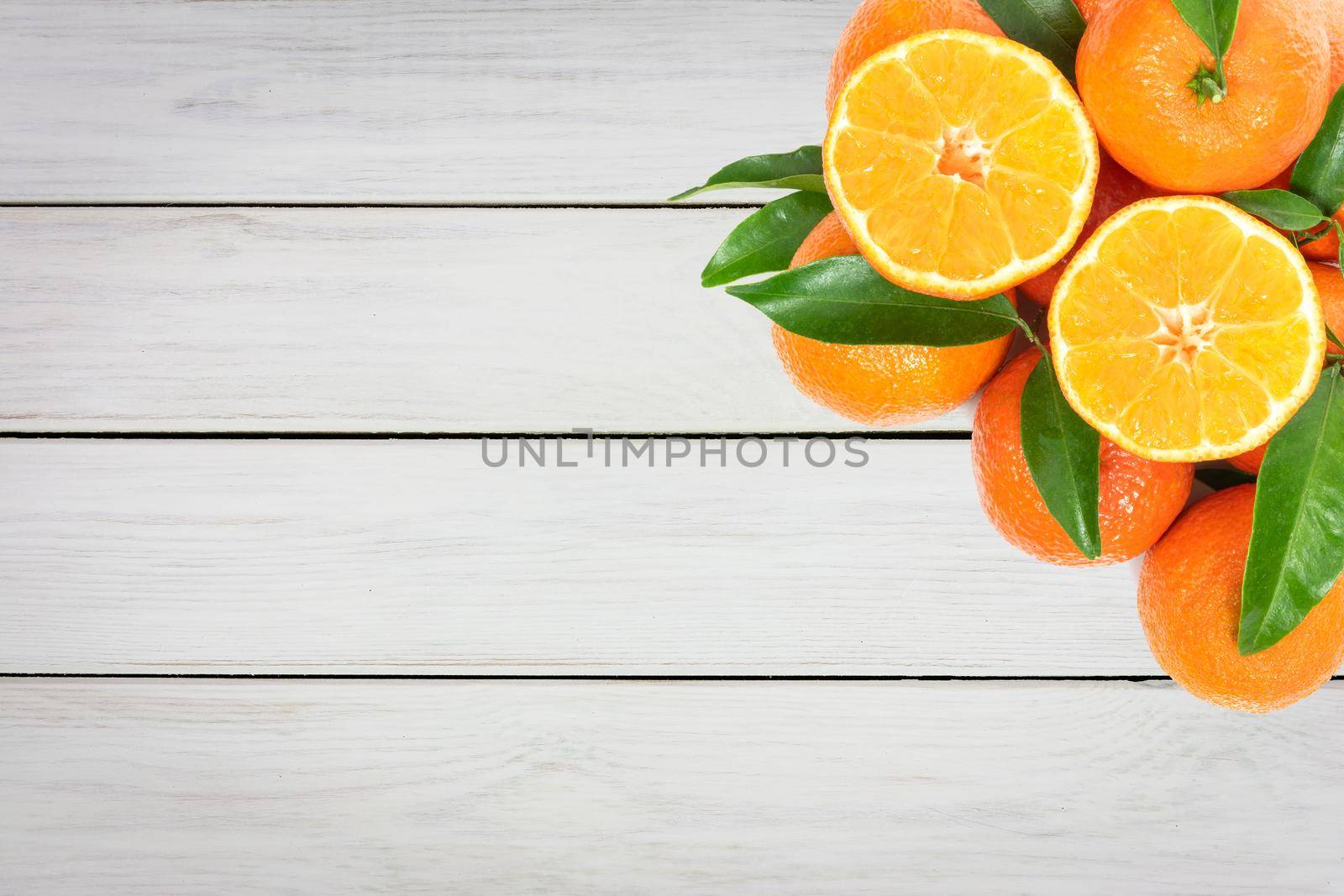 Tropical fruit composition - group of fresh oranges or tangerines  on a wooden vintage table (copy space)