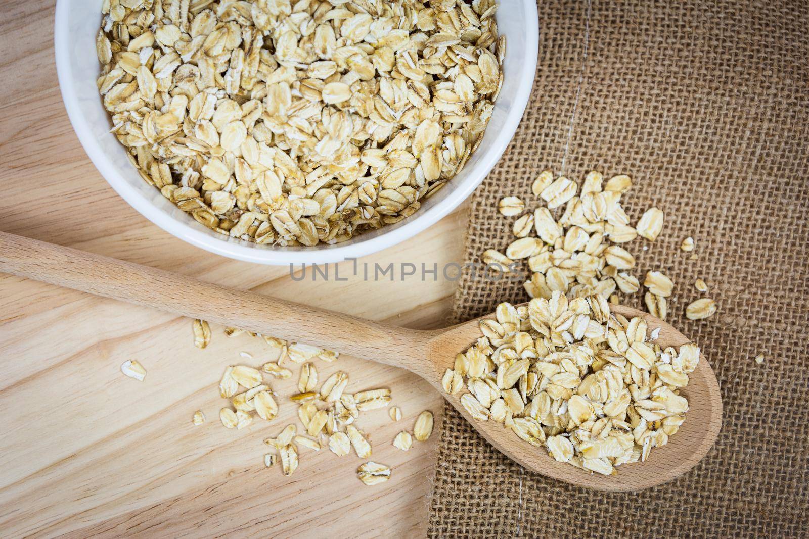 Top view of oatmeal flakes on a wooden table in a rustic style