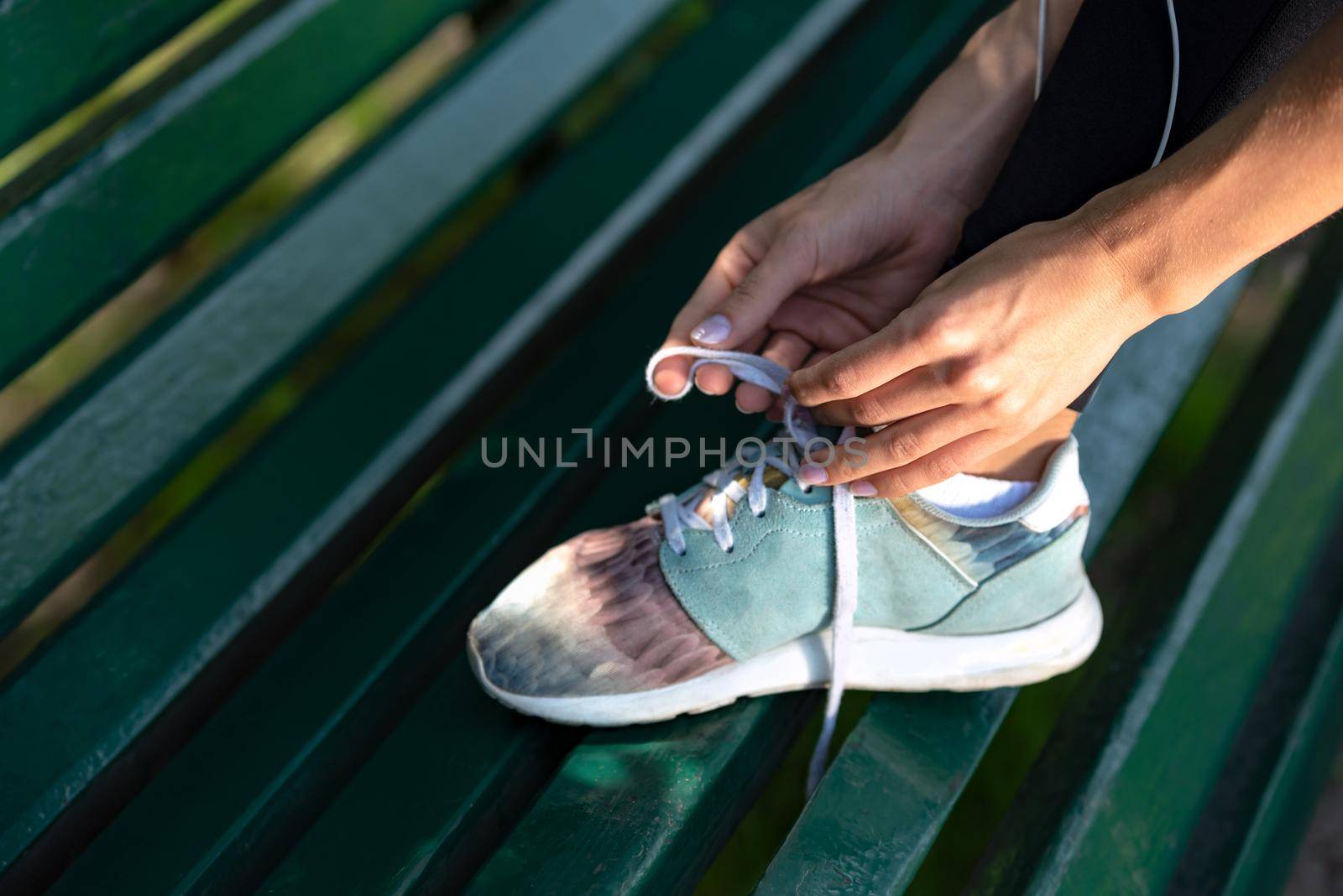 Woman lacing sports shoes by wdnet_studio