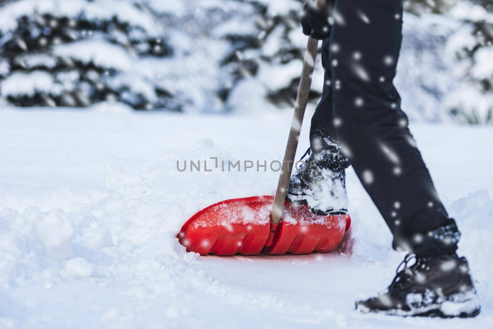 Public service worker or citizen shoveling snow during heavy winter blizzard