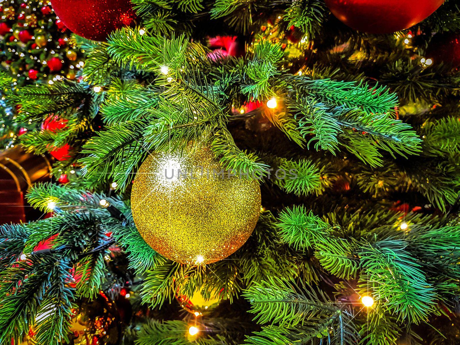 Beautiful Christmas background - shiny baubles on a background of blurred lights on a Christmas tree with bokeh effect.