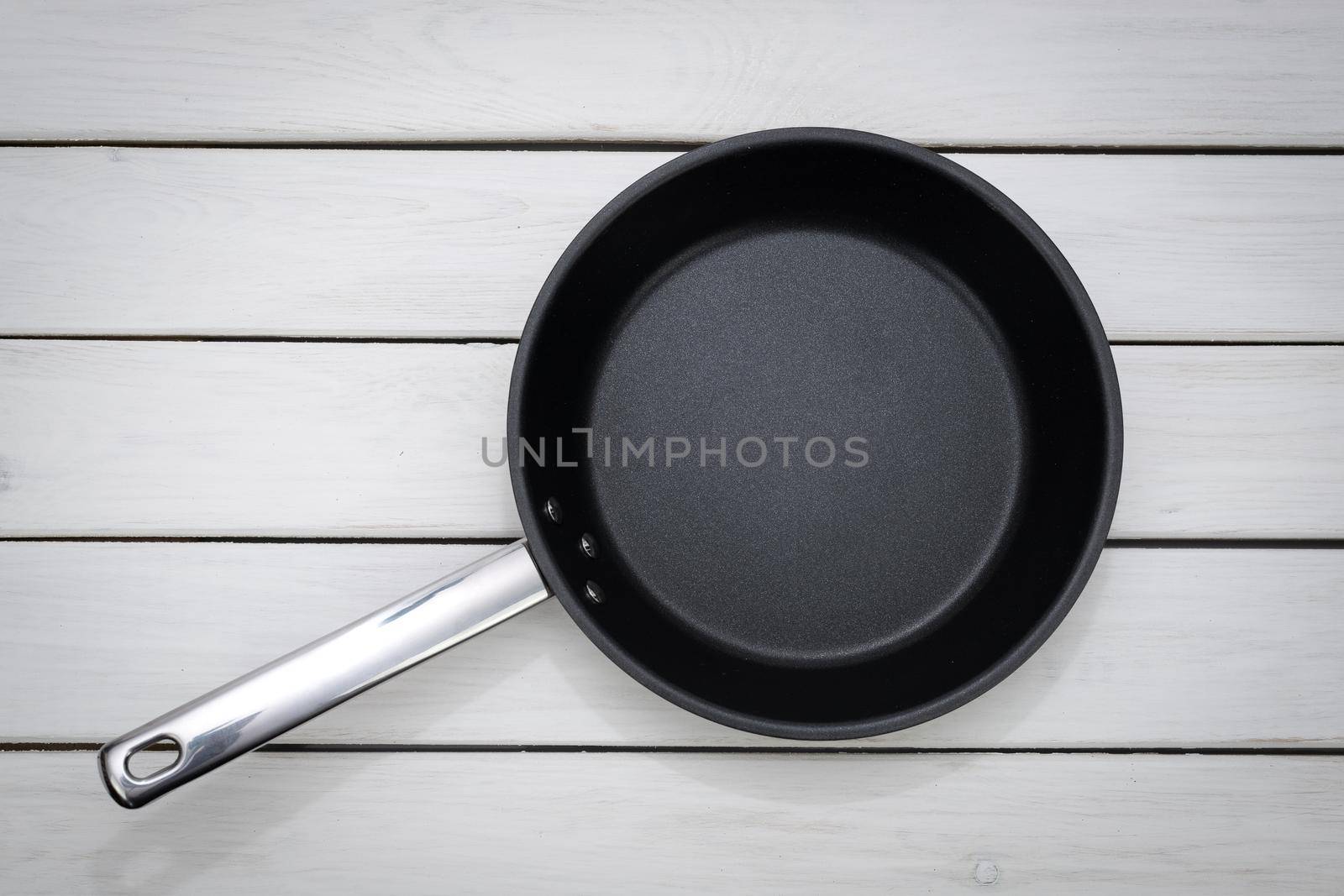 Black fry pan on the table by wdnet_studio