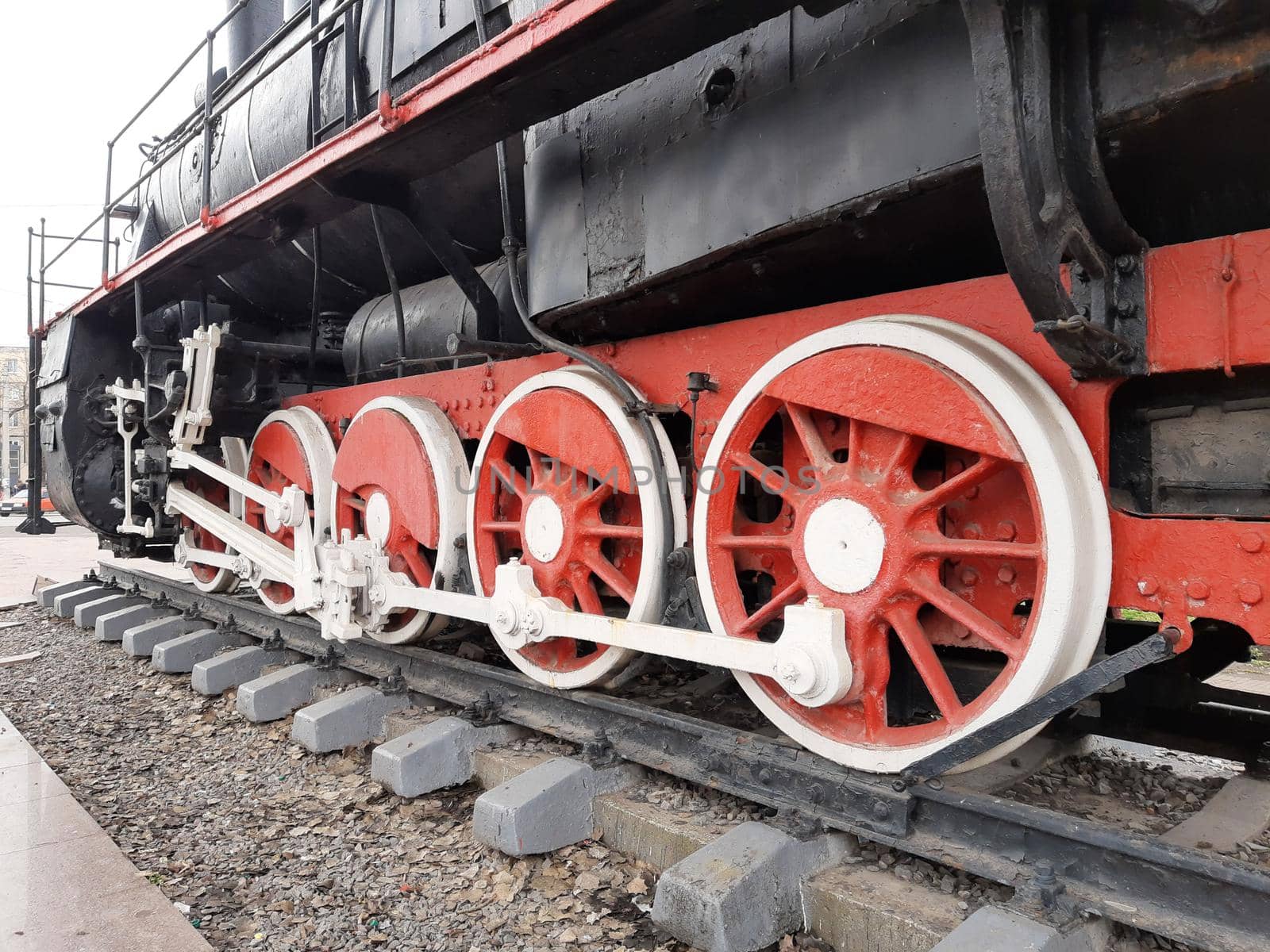 Wheels of an old steam locomotive on rails close-up.